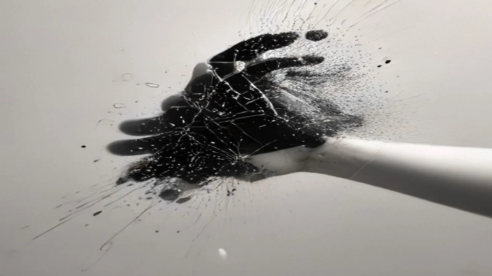 Mão abstrata em preto e branco que se fragmenta em partículas e linhas finas em movimento