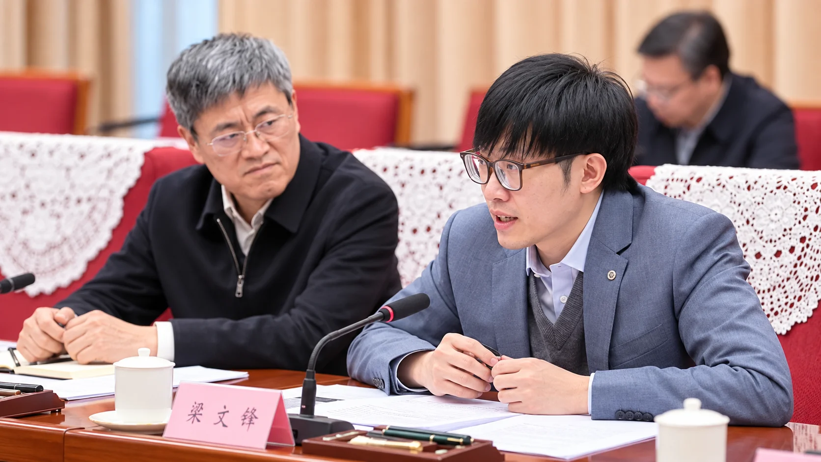 Liang Wenfeng durante reunião oficial na China.