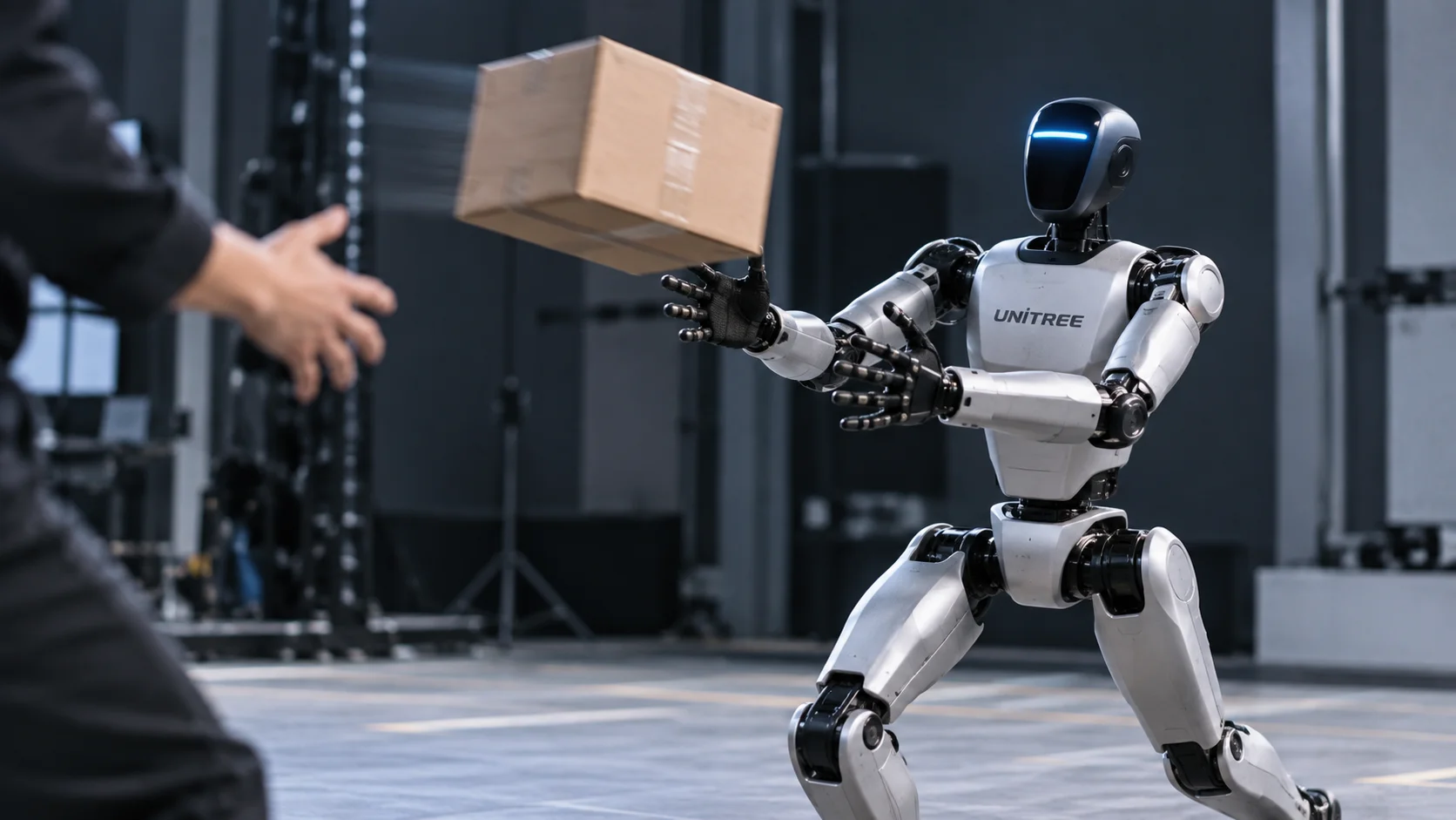 Editorial illustration of a Unitree humanoid robot reaching to catch a cardboard box thrown by a person in a robotics laboratory.