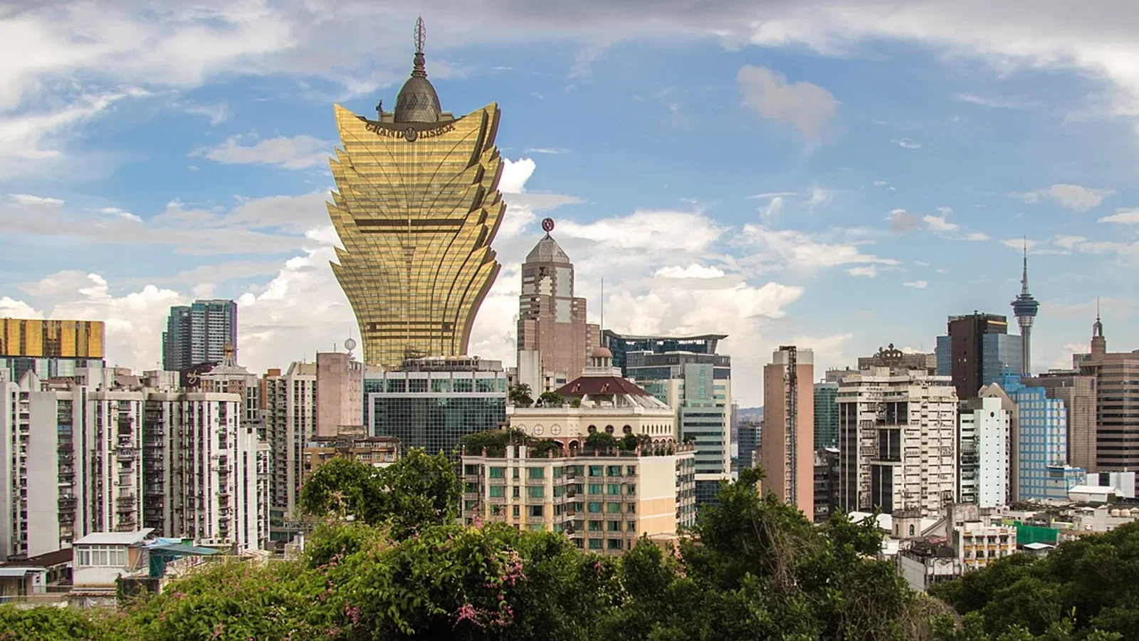 Panorama of Macau's skyline dominated by the Grand Lisboa hotel and casino building, with a design inspired by a lotus flower.