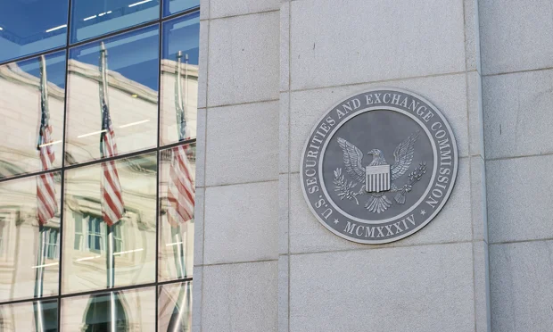 Facade of the SEC headquarters in Washington, with the Securities and Exchange Commission seal and United States flags reflected in the glass.