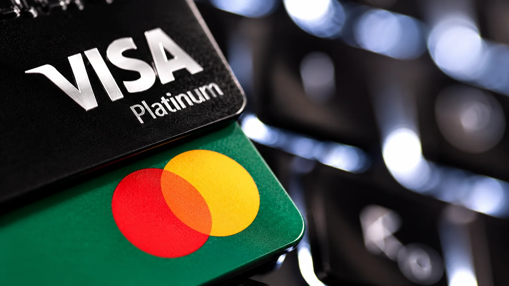 Visa and Mastercard cards overlapping in close-up, with focus on the two brands' logos.