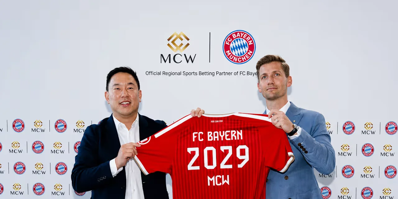 Two representatives pose holding a red Bayern de Munique shirt with “2029” and “MCW”, in front of a panel with the club's and Mega Casino World's brands.