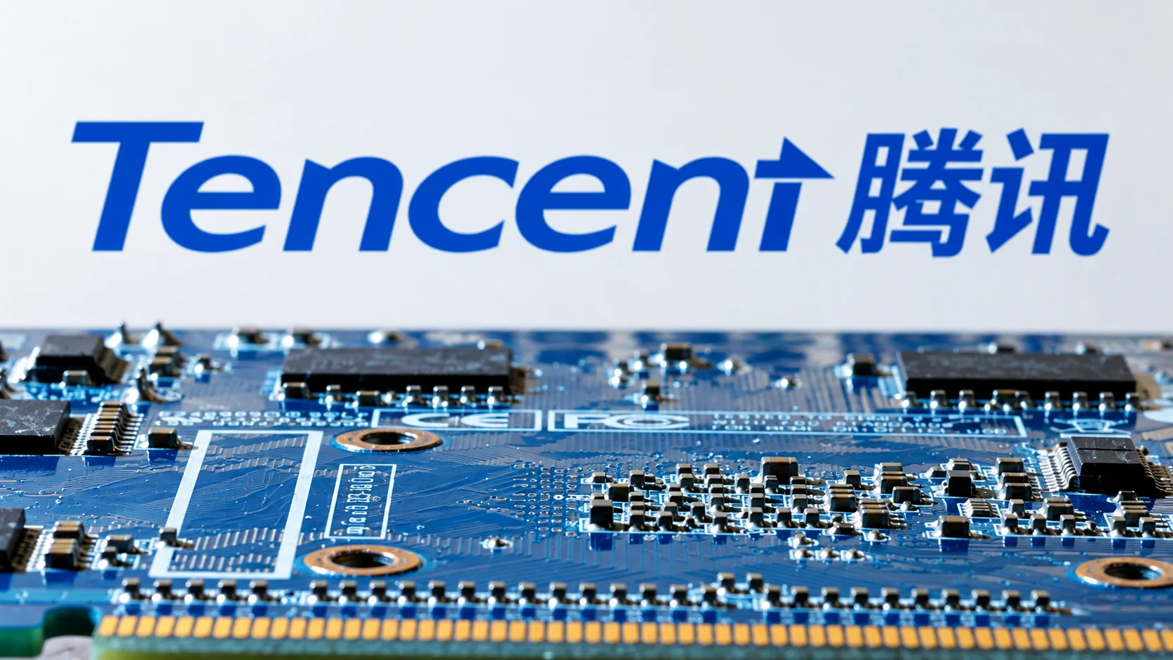 Tencent logo in blue in the background, with an electronic circuit board in the foreground.