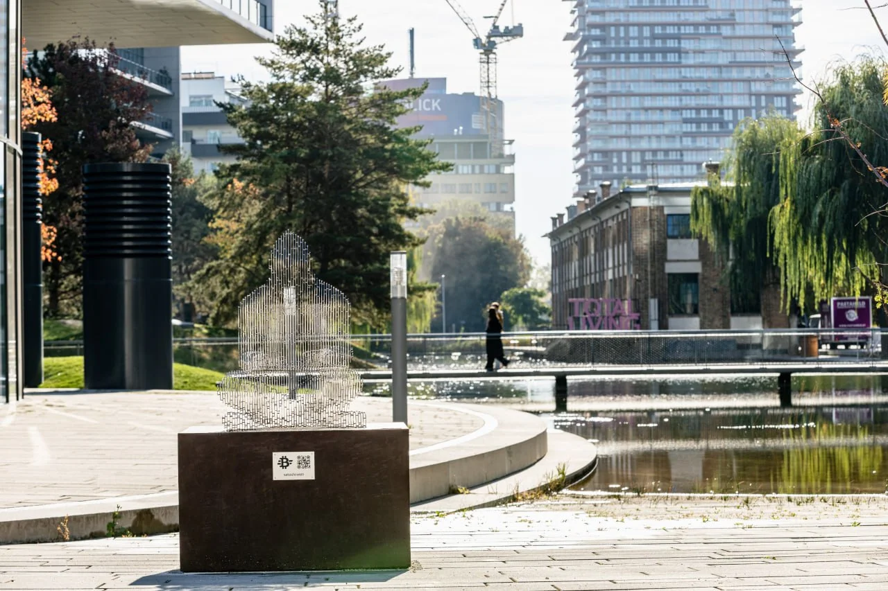 Vista frontal da estátua de Satoshi Nakamoto em Viena mostra como as camadas de aço criam um efeito de transparência, simbolizando o anonimato do criador do Bitcoin. Foto: Max Peternell / Bitcoin Austria.